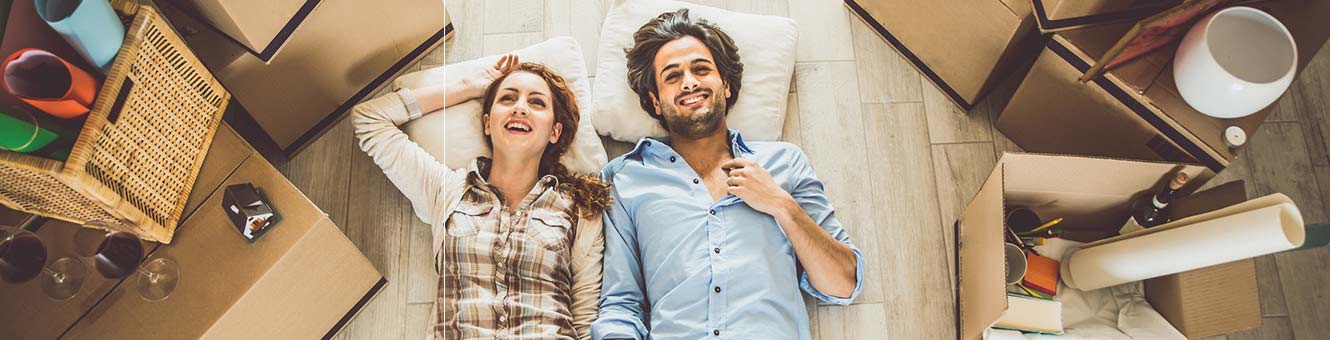 Exhausted couple lying on the floor of their new house.