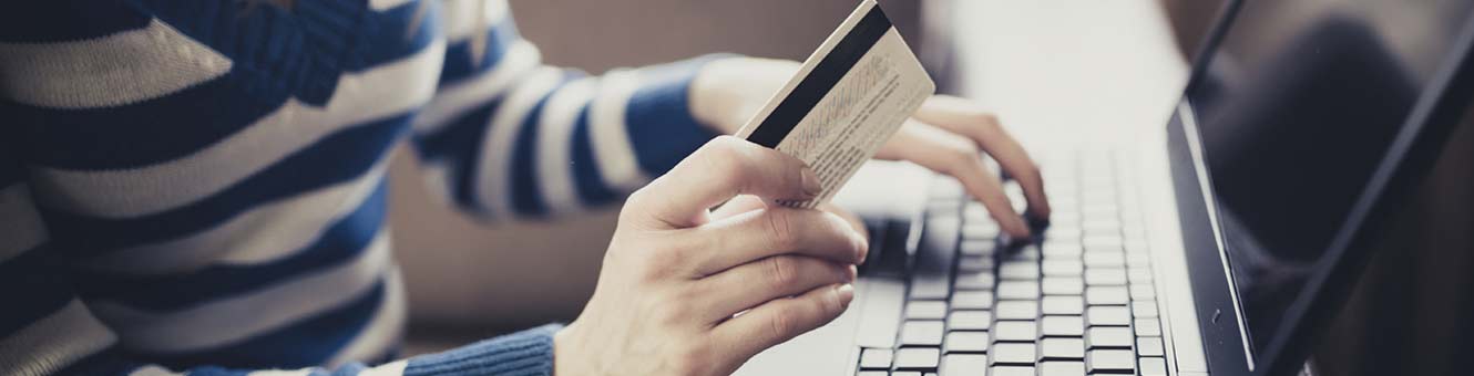 Young lady holding her credit card shopping online.