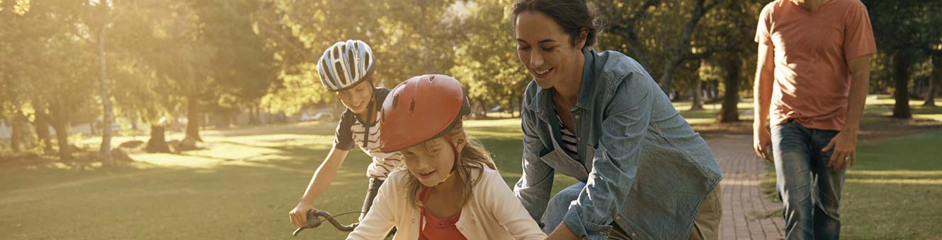 Father and mother teaching their children to ride bikes.