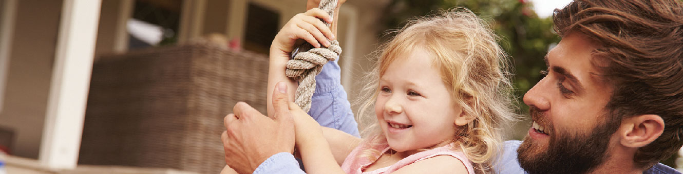 Father and daughter on a tire swing.