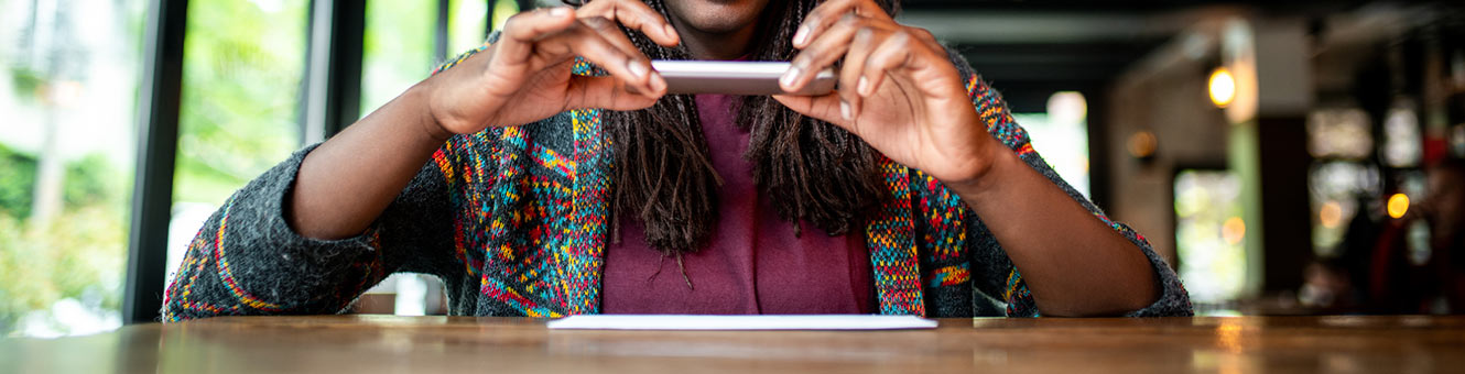 Woman using phone to remote deposit a check.